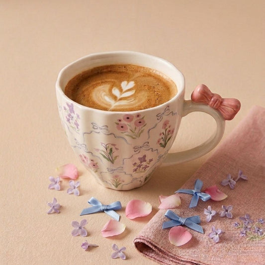 TAZA BLANCA DE FLORES CON LAZO ROSADO EN EL ASA