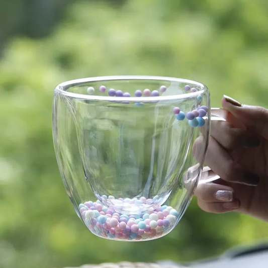 TAZA DE VIDRIO TRANSPARENTE DOBLE CAPA CON PELOTITAS DE COLORES EN EL FONDO